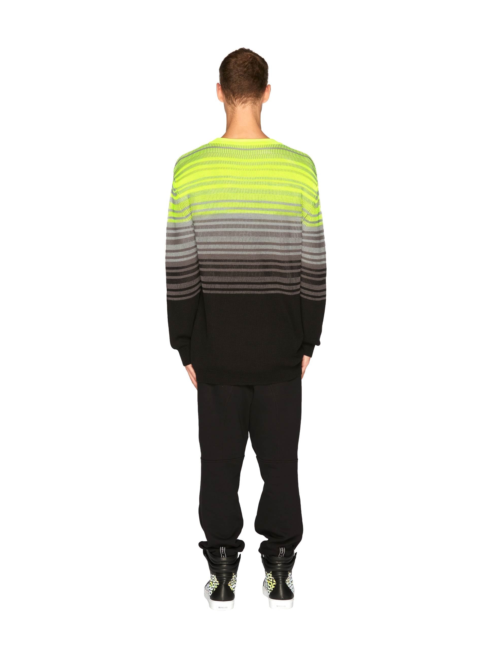 Knit Fluo Crewneck in gradient neon green to black, paired with relaxed black pants and stylish sneakers - Byblos contemporary flair