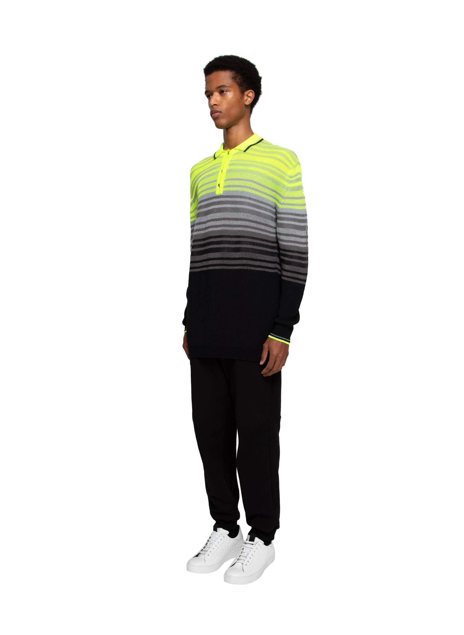 Striped knit  fluo polo in vibrant yellow, gray, and black, paired with black joggers and white sneakers for a contemporary casual look.